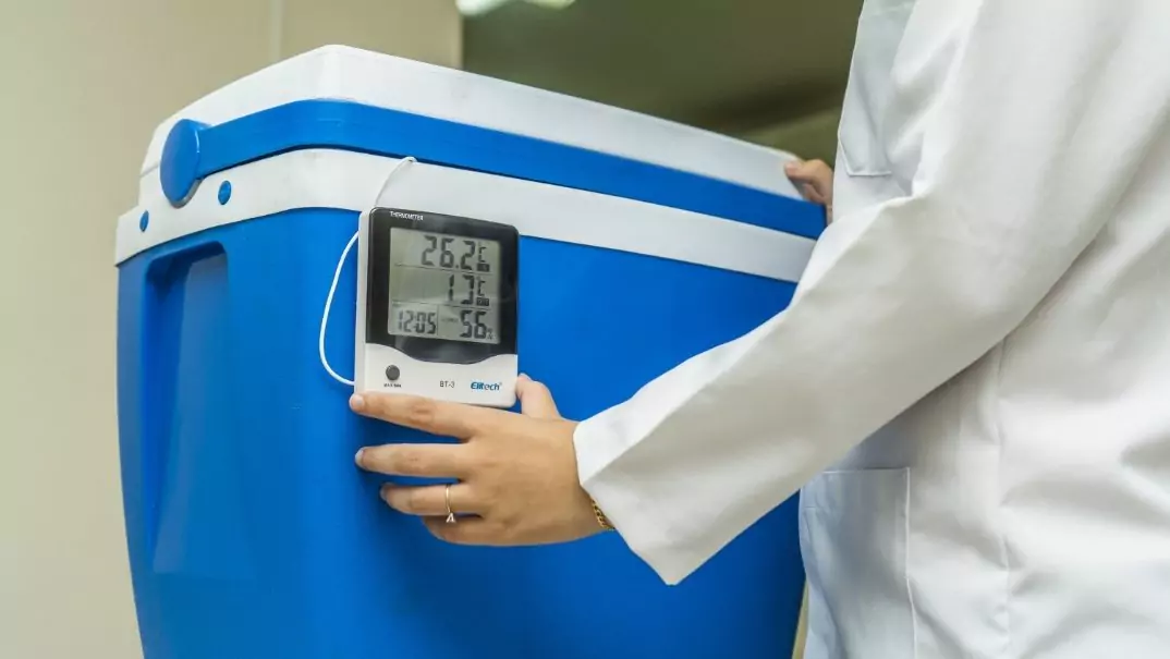 BT-3 Termohigrômetro Pessoa de jaleco branco utilizando o BT-3 termohigrômetro em uma caixa térmica azul e branco.